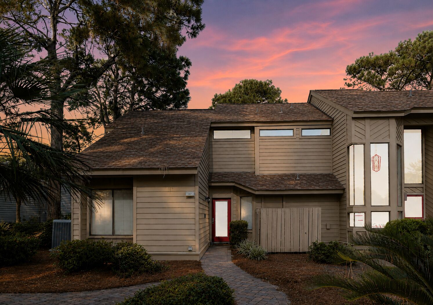 A two-story residential house with a covered garage, a front porch, and a driveway.