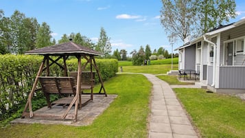 A gazebo with benches, a pathway, and a building with outdoor seating.