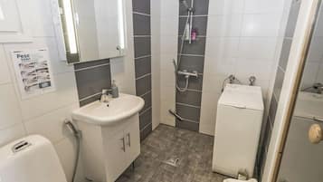 Ein Badezimmer mit Waschbecken, Spiegel, Dusche, Toilette und Bidet.