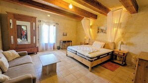 Quarto com cama, guarda-roupa de madeira, escrivaninha e cadeira.