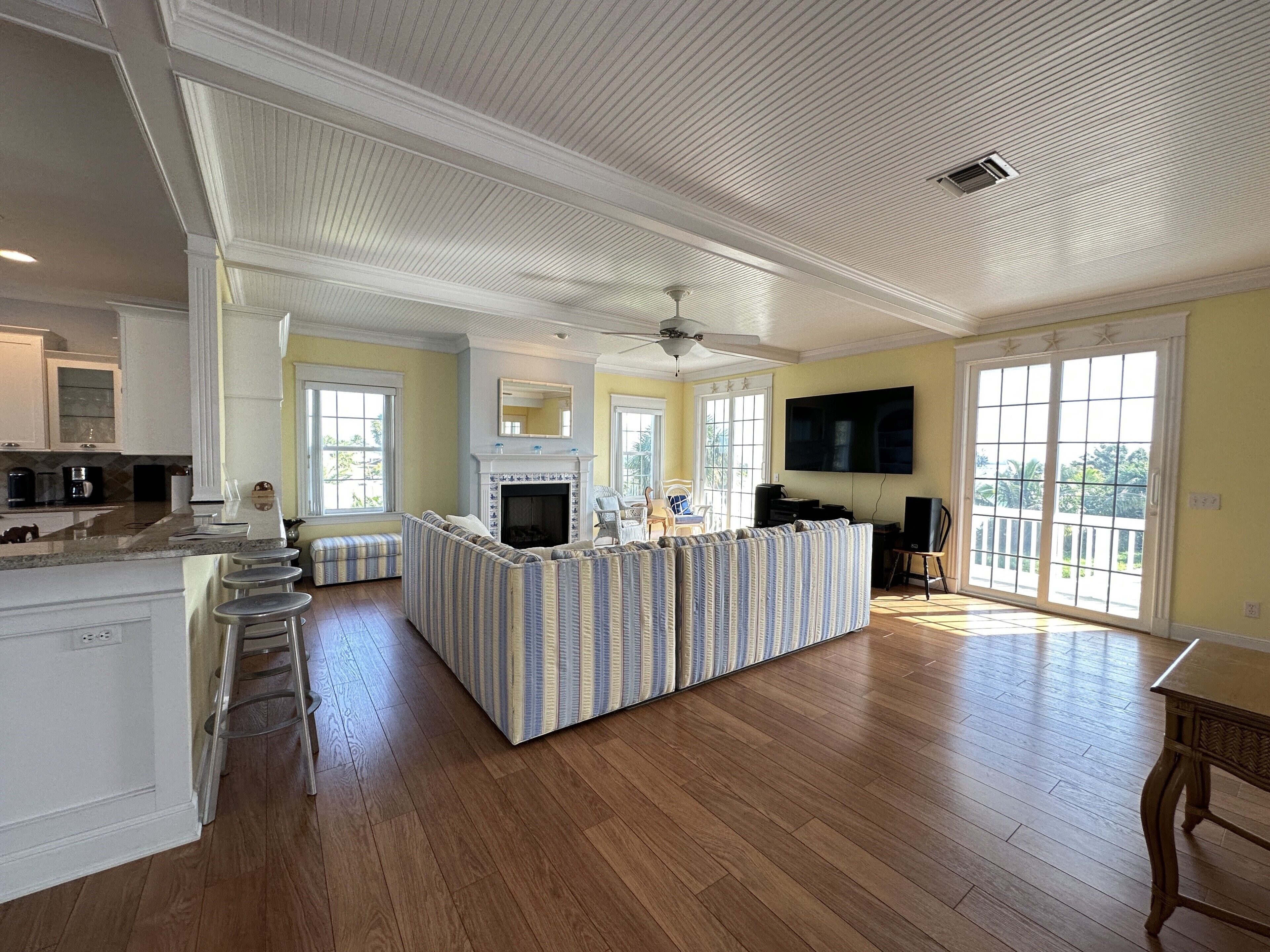A spacious living area with a large island, a fireplace, and a TV mounted on the wall.