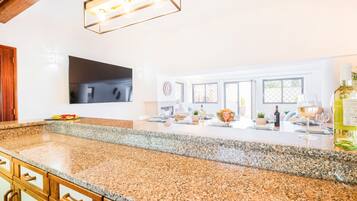 A modern kitchen with granite countertops, a built-in oven, and a large window overlooking a garden.