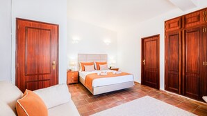 A hotel room with a bed, a sofa, a nightstand, and a wardrobe. - Luxury retreat w/ heatable pool & jacuzzi (Albufeira)