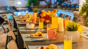 A dining table set with plates, cutlery, and various beverages, including juice and water, in a restaurant setting. - Luxury retreat w/ heatable pool & jacuzzi (Albufeira)