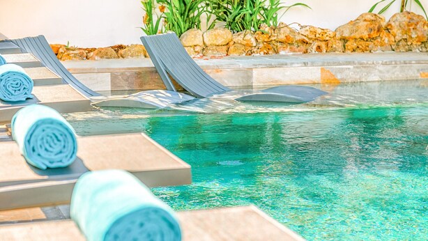 A pool area with lounge chairs and a stone border. - Luxury retreat w/ heatable pool & jacuzzi (Albufeira)
