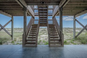 A wooden staircase leading to an outdoor area with a clear view of the beach and dunes. - Knotty in the Kitchen: Oceanfront Near Park (Oak Island)
