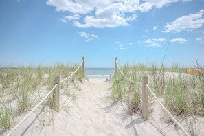 A sandy beach path leading to the ocean with a clear sky. - Knotty in the Kitchen: Oceanfront Near Park (Oak Island)