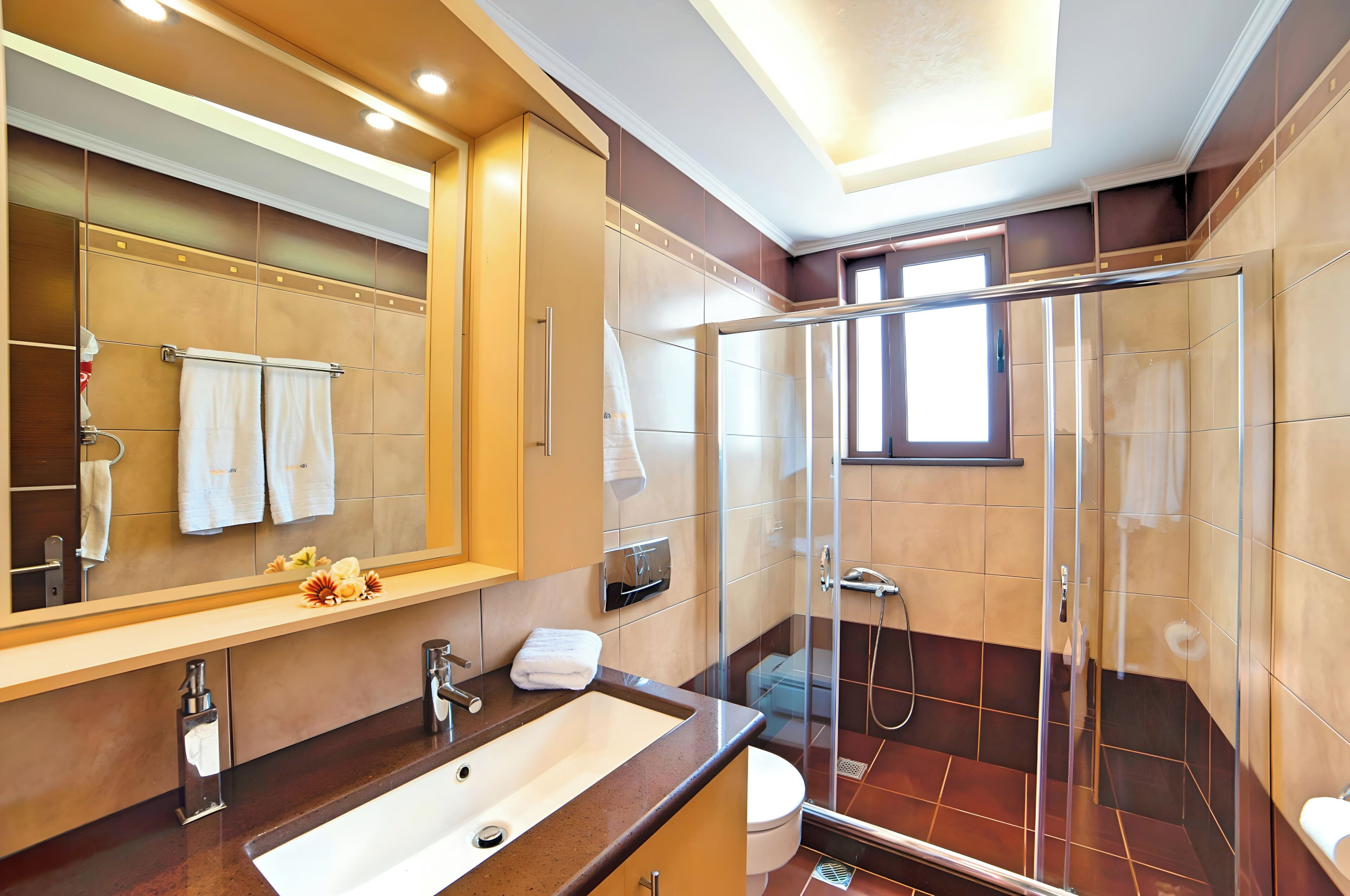 Un bagno moderno con uno specchio grande, un lavandino, una doccia e un water.