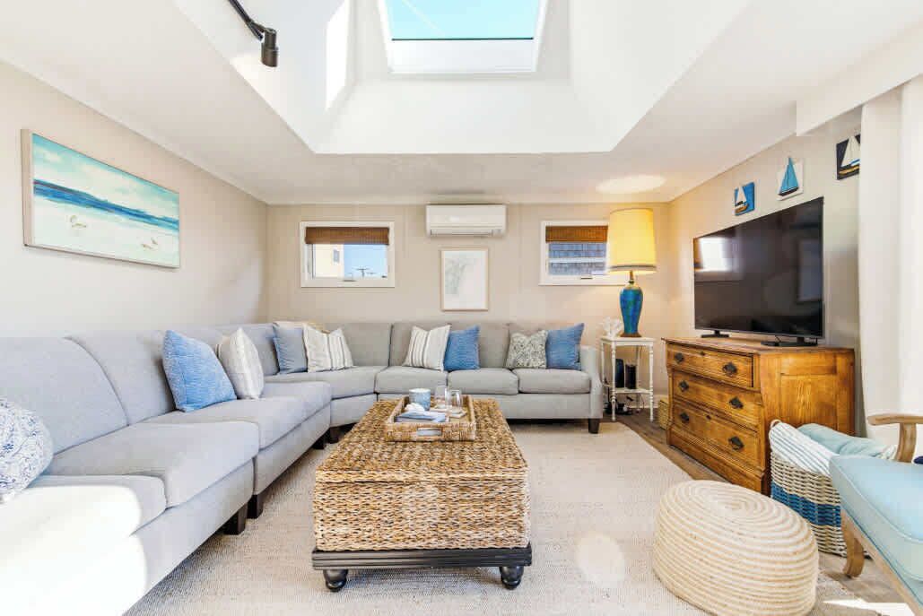 A living room with a sofa, a coffee table, a TV, and a lamp.