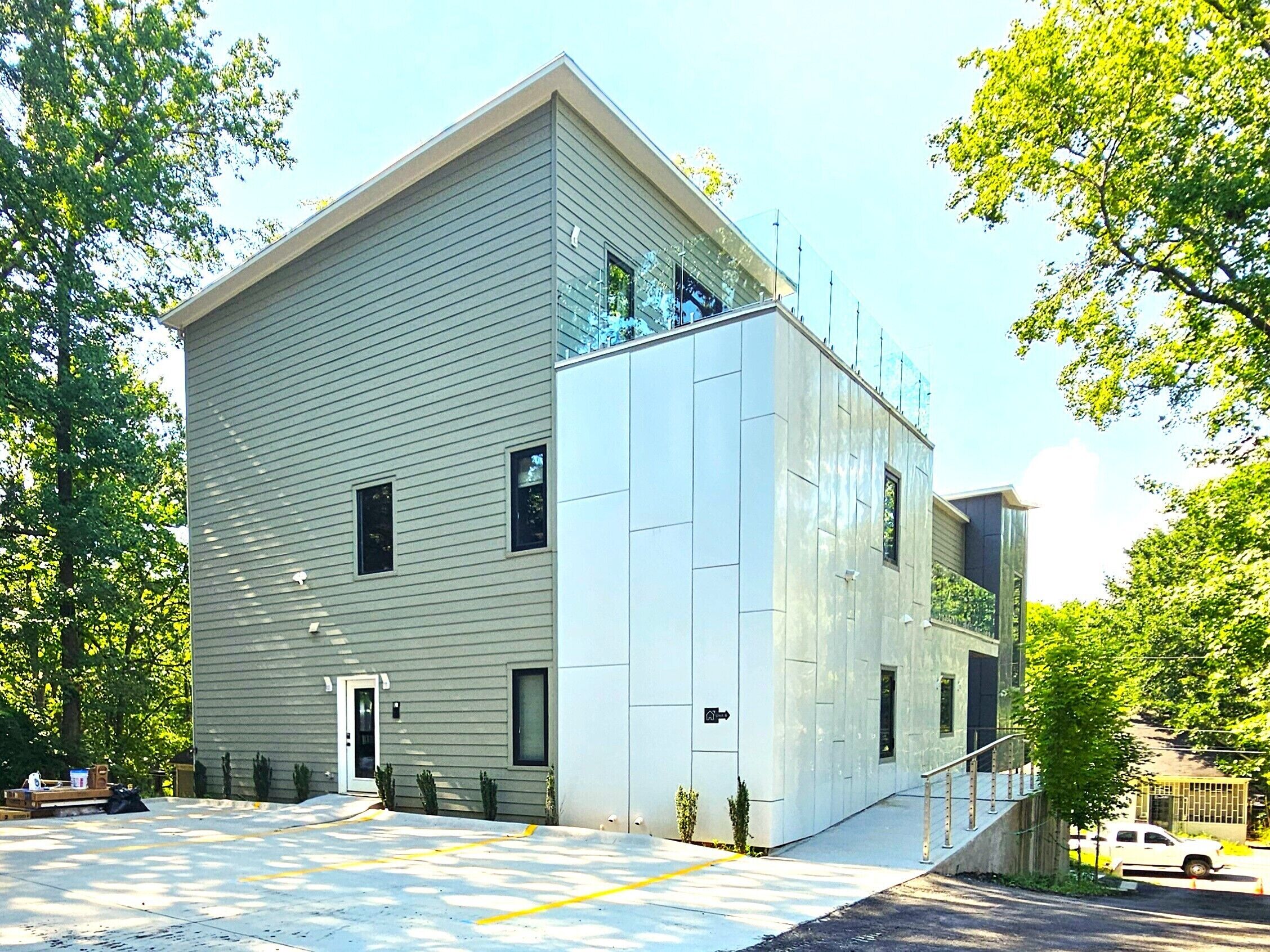A modern building with a flat roof, large windows, and a visible entrance.