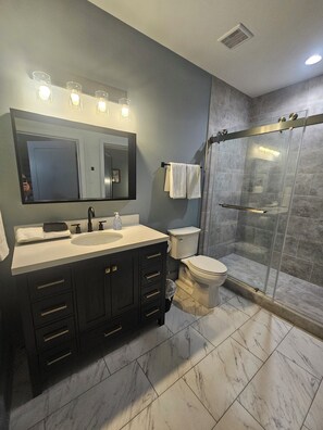 A modern bathroom with a large mirror, vanity, sink, and toilet. - Large Midtown near GA Tech home great for Corporate stays- 3 King Beds (Atlanta)