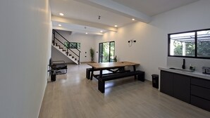 Una cucina moderna con un tavolo in legno, un lavello incassato e una scala che conduce a un altro piano.