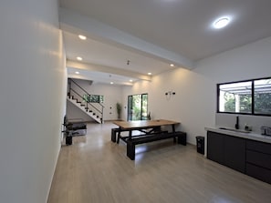 A modern kitchen with a wooden table, a built-in sink, and a staircase leading to another level.