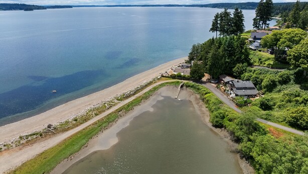 A coastal property with a beach, a small lake, and dense greenery. - Hidden Harbor Getaway-Sunrise Views-Private Beach Access (Gig Harbor)
