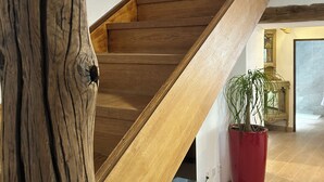 A wooden staircase with a red planter and a white cabinet at the bottom.