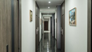 A corridor with doors on both sides, a tiled floor, and a framed picture on the right wall. - Gulshan Hotel (Urgench)