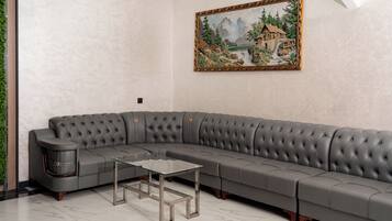 Un sofá seccional gris con una mesa de centro de vidrio en una habitación con un cuadro en la pared.