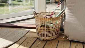 A wicker basket on a wooden deck, a beige cushion, and a view through a glass door. - Personal style in a home between Vig and Høve (Vig)