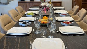 A dining table set for a meal with plates, cutlery, and glasses, surrounded by chairs. - Rental: Gazost Fountains (Gazost)