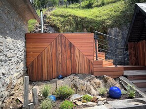 A wooden structure with a metal staircase and a stone wall.