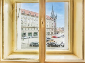 Ein Fenster mit Blick auf eine Straße, Gebäude und ein Kirchturm.