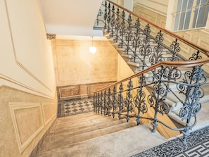 Eine prächtige Treppe mit aufwendiger Metallgeländerung und einem Schachbrettmuster-Teppich.