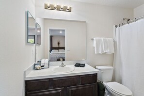 A bathroom with a sink, mirror, and toilet. - Tropical Oasis 2 bdr - patio, playground, dog park (Jacksonville)
