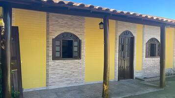 A building with a yellow facade, arched windows, and a tiled roof.