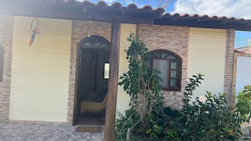 Una casa con tetto a tegole, una porta con finestra e un piccolo giardino.