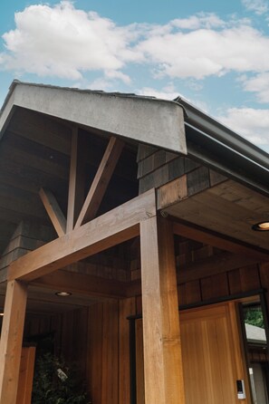 A building with a wooden facade, a sloped roof, and a visible entrance. - Cabin with Sauna & Cold Plunge, 8 people + kids (Salt Spring Island)