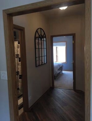 A hallway with a wooden door frame, a metal gate, and a bed in the adjacent room. - 2-bedroom apartment in pleasant Oak Lawn with AC comfort (Oak Lawn)