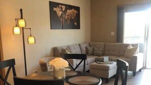 Ein Wohnzimmer mit einer Couch, einem Couchtisch und einem Esstisch mit Stühlen.