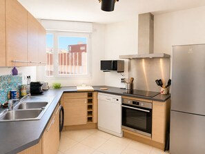 Eine moderne Küche mit Geschirrspüler, Backofen, Mikrowelle und Kühlschrank.
