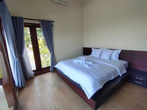 Una camera da letto con un letto, tende e vista su del verde all'esterno.