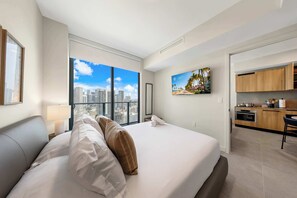 A hotel room with a large bed, a city view, a kitchen area, and a framed picture on the wall. - We Host at 501 Residences - Miami Experience (Miami)
