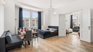 Quarto moderno com cama, sofá, mesa de jantar e uma cadeira.