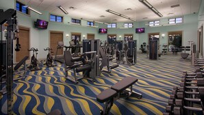 A gym with various exercise equipment, a patterned carpet, and multiple TV screens on the walls. - 5BR ChampionsGate Home with Pool & Water Park (Championsgate)