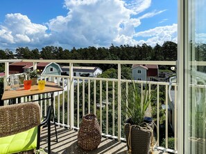 A balcony with a table, wicker furniture, and potted plants. - 5 Star Holiday Home in Morbylanga (Morbylanga)