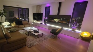 Un salon moderne avec un canapé, une table basse et un téléviseur à écran plat.