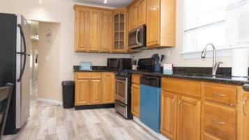 A kitchen with wooden cabinets, a microwave, a dishwasher, and a refrigerator.
