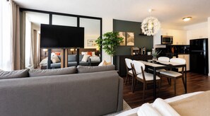 A modern living room with a sofa, dining table, chairs, and a kitchen area with appliances. - Modern Studio in the Center of Miami Beach's Entertainment District (Miami Beach)