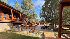 Ett trädäck med en stenlagd gång som leder till en stuga.