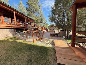 Una terraza de madera con un sendero de piedra que lleva a una cabaña.