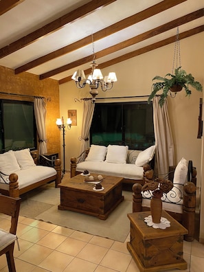 Una sala de estar acogedora con un sofá, una mesa de centro de madera y una planta colgante.
