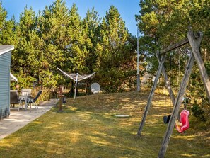 A backyard with a swing set, a satellite dish, and a patio with outdoor furniture. - "Into" - 490m from the sea by Interhome (Sæby)