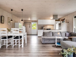 A modern interior with a dining area, kitchen, and living space. - "Melisande" -  from the sea by Interhome (Storvorde)