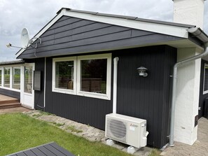 A building with a dark exterior, white trim, and a satellite dish. - "Melisande" -  from the sea by Interhome (Storvorde)