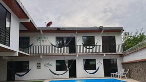 A two-story building with a swimming pool, a hammock, and a satellite dish. - Cozy country house with swimming pool and comfort only 5 min. from the city. (Villavicencio)