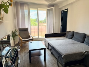 A modern living room with a sofa, armchair, and a small table. - Two-bedroom apartment within a 10-minute walk of downtown (Aix-en-Provence)