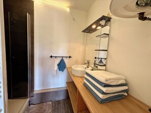 A bathroom with a shower, a sink, a mirror, and a towel rack. - Two-bedroom apartment within a 10-minute walk of downtown (Aix-en-Provence)